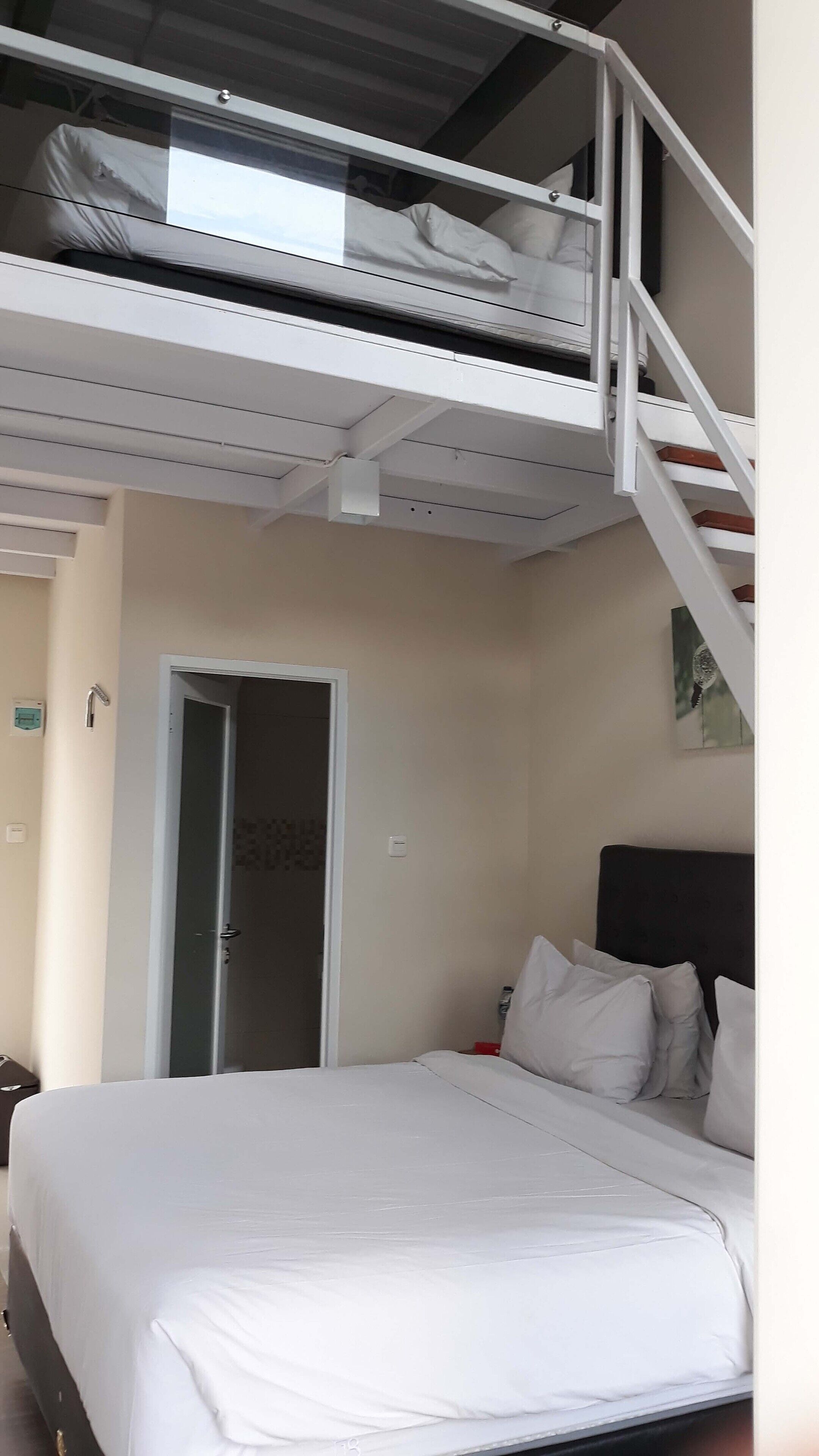 Une chambre à coucher avec un lit, une porte et un escalier menant à un étage supérieur.