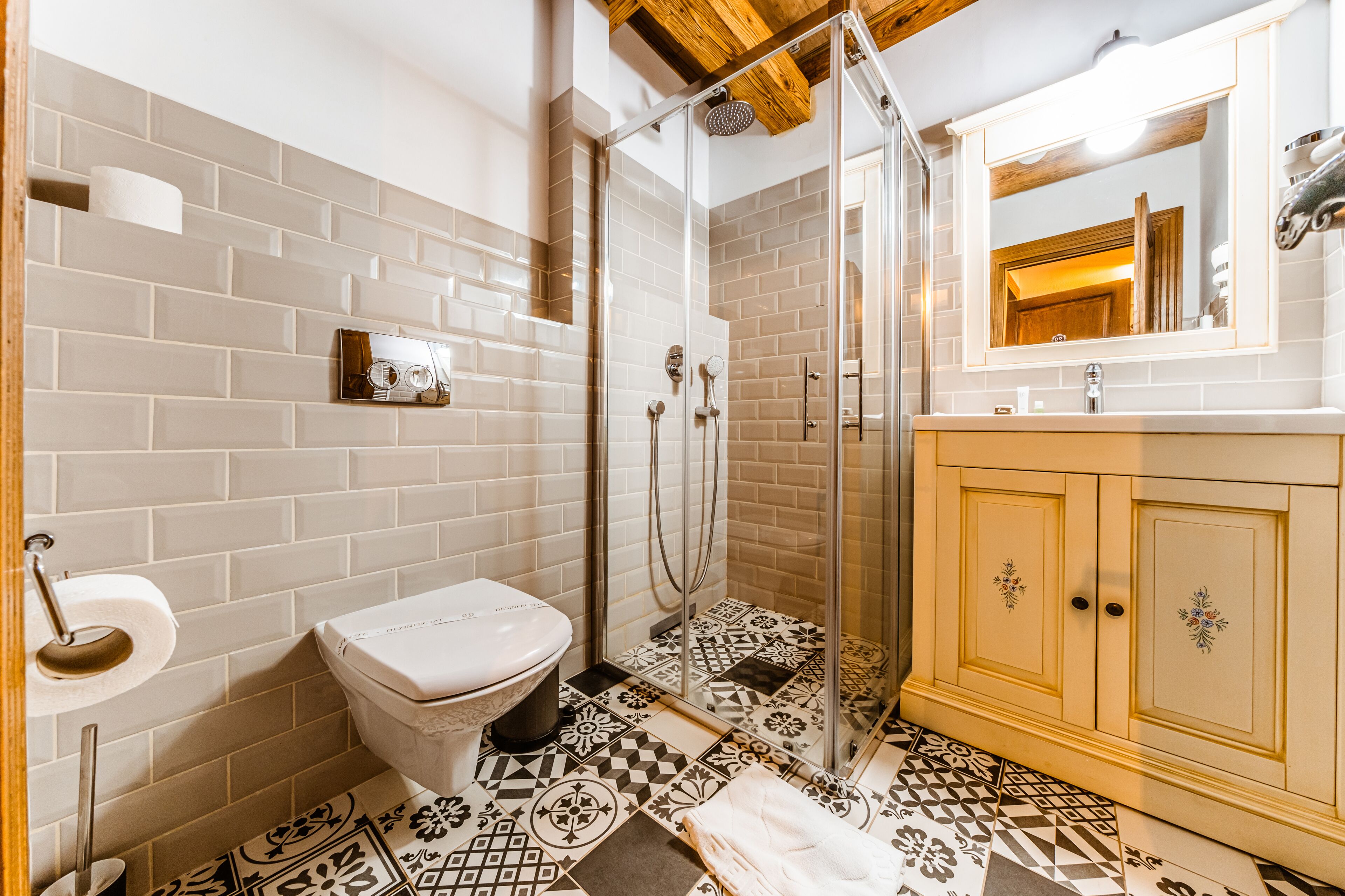 Une salle de bain équipée de toilettes, d’une douche et d’un meuble-lavabo avec un miroir.