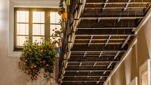 A hotel interior with multiple windows, a staircase, and hanging plants. - Casa Chitic Hotels (Brasov)