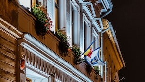 A historic building with ornate architecture, a sign reading "CASA CHITIC," and flower boxes on the windowsills. - Casa Chitic Hotels (Brasov)