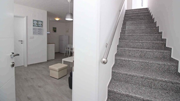 A modern interior with a staircase, a dining area, and a kitchen. - Holiday apartment with air conditioning and internet, near the sea (Baška)