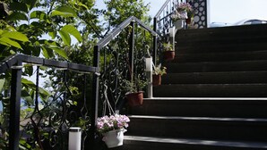 A staircase with a metal railing, potted plants, and a decorative archway. - Kazdagları Saglikli Yasam Tatil Koyu (Edremit)