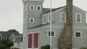 Ein großes, mehrstöckiges Gebäude mit einem markanten Turm und einem Steinkamin.
