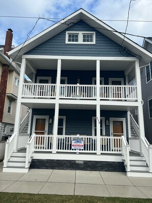 A two-story house with a front porch, a chimney, and a sign indicating a listing number. - GREAT OCEAN CITY LOCATION-NEXT TO BEACH & BOARDWALK! (Ocean City)