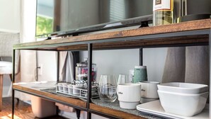 A kitchen counter with a coffee maker, glasses, and bowls. - Charming Downtown 1 BR (Charleston)