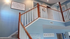 A staircase with wooden railings and a sign that reads "BEACH HOUSE".