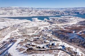 A snow-covered landscape with a small settlement featuring houses and a winding road.