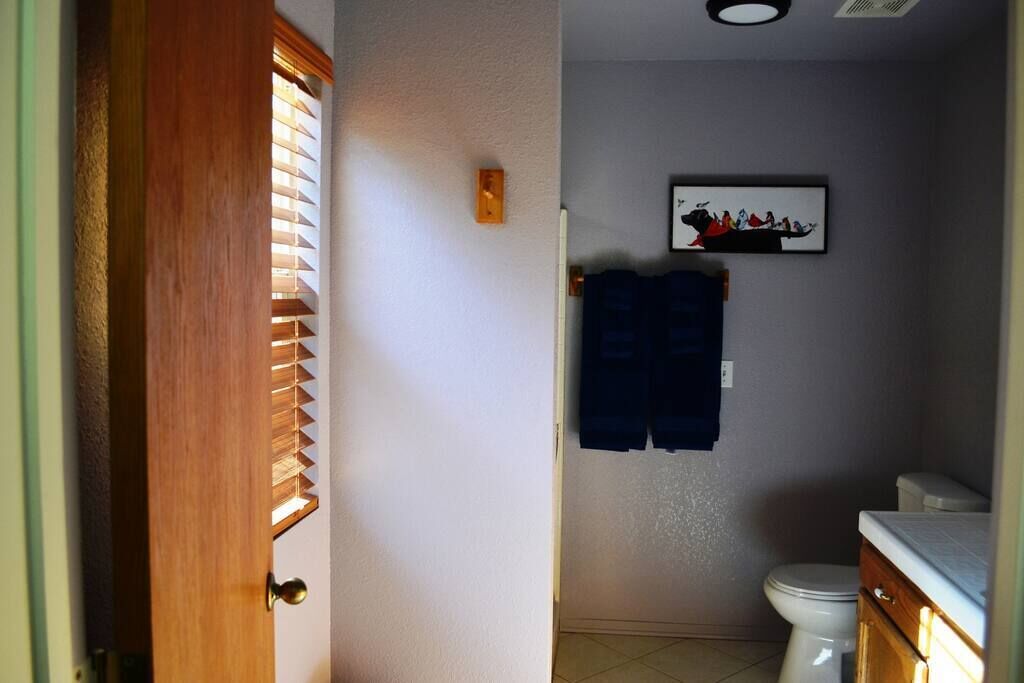 A bathroom with a toilet, a sink, and a towel hanging on the wall.