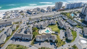 A coastal residential area with a central swimming pool, multiple-story buildings, and a beach in the background. - Private Resort Villa•Beach Service & Golf Cart Included• Boat & Trailer Friendly (Destin)