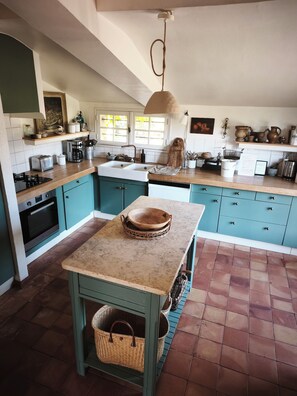 A kitchen with teal cabinetry, a marble countertop, and a hanging light fixture. - Charming 17th century house on 1 ha of land 4 minutes from Bergerac (Bergerac)