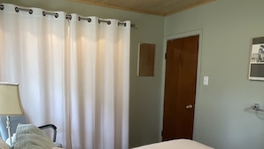 A bedroom with a bed, a chair, a lamp, and a door. - Quiet home on horse farm, halfway between Paducah & Wickliffe. Close to 60 & 286 (Kevil)