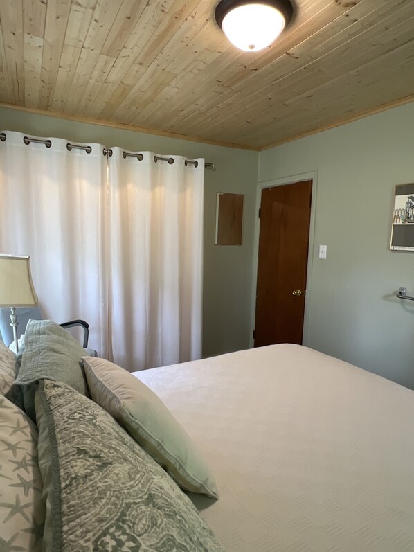 A bedroom with a bed, a chair, a lamp, and a door. - Quiet home on horse farm, halfway between Paducah & Wickliffe. Close to 60 & 286 (Kevil)