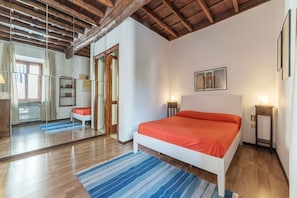A bedroom with a bed, bedside tables, a mirror, and a wooden ceiling. - GuestHost - Apartment located on the second floor of a typical period building without a lift.In 55 square meters of space it comfortably accommodates 3 people.Located in a strategic position a short distance from the Colosseum, the Colle Oppio Park and  (Roma)