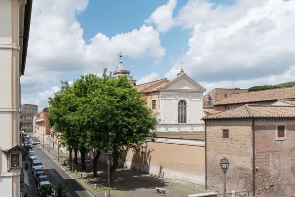 A street with a large tree, a white building with a dome, and the Colosseum in the background. - GuestHost - Apartment located on the second floor of a typical period building without a lift.In 55 square meters of space it comfortably accommodates 3 people.Located in a strategic position a short distance from the Colosseum, the Colle Oppio Park and (Roma)