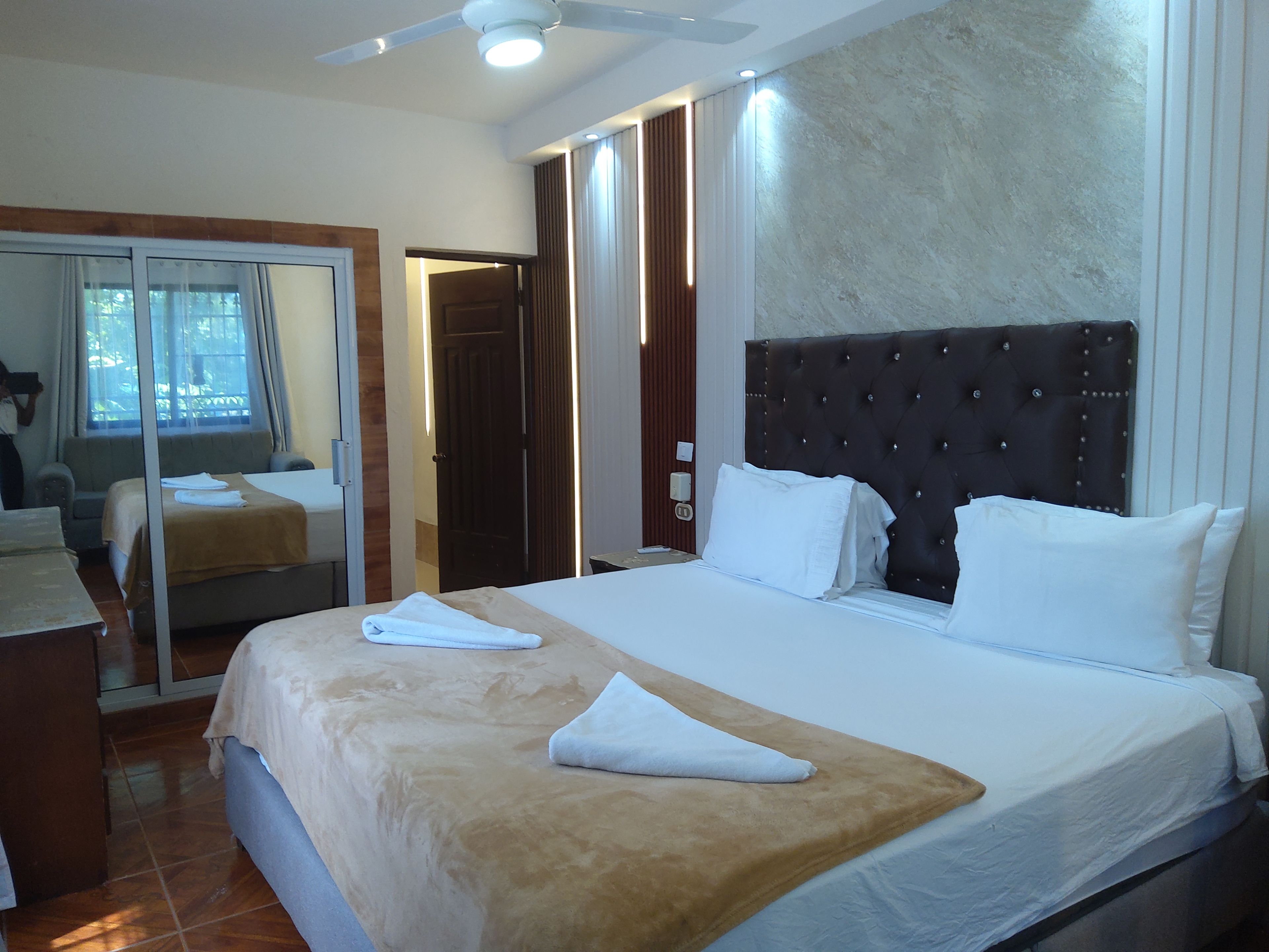 Ein Hotelzimmer mit Bett, Bad und Blick nach außen.