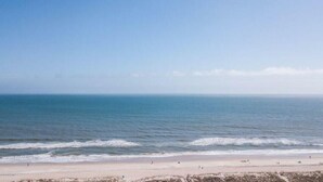 Ein Strand mit blauem Himmel und ruhigem Wasser.