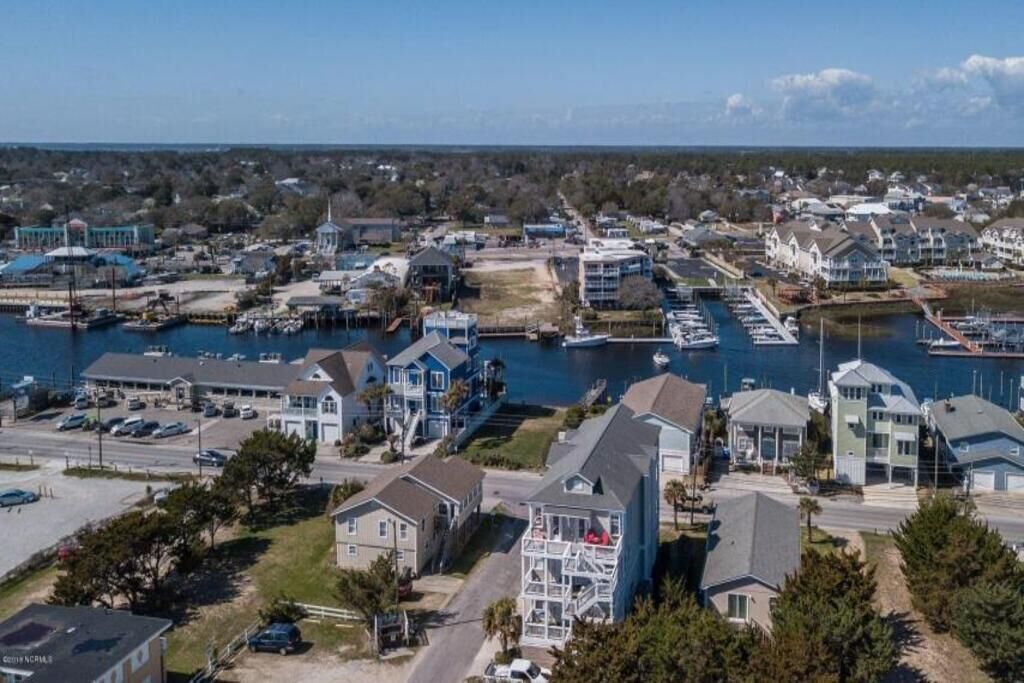 A coastal residential area with houses, a marina, and a large body of water.