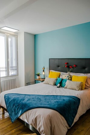 Une chambre à coucher avec un lit, une table de chevet, une fenêtre et une vue sur l’extérieur.