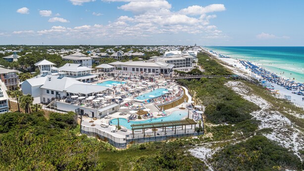 Um resort com várias piscinas, uma praia e vista para o oceano.