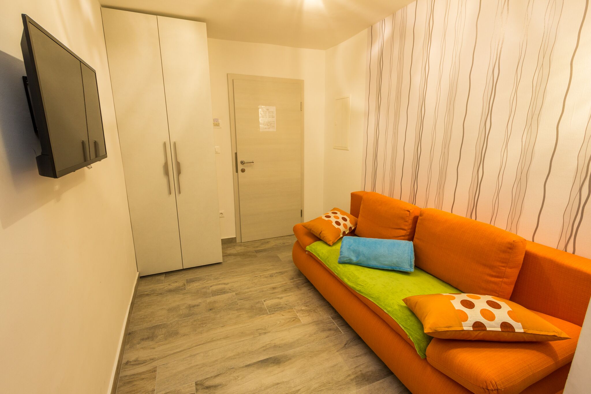 Una habitación con sofá, televisión y armario.