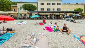 A beachside area with outdoor seating and umbrellas, a building labeled "APARTHOTEL GIMI" in the background, and people relaxing on the sand. - Aparthotel Gimi (Moscenicka Draga)