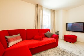 Deluxe Apartment | Living area | 85-cm flat-screen TV with cable channels, TV, toys