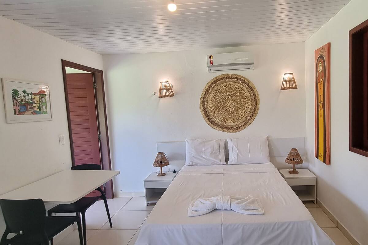 Une chambre d’hôtel comprenant un lit, des tables de chevet, un bureau et des chaises.