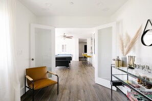 Relax in a stylish seating area with a comfortable chair and a glass display shelf.