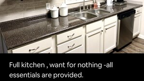 A full kitchen with white cabinets, a granite countertop, and a dishwasher. - BestStays@Flowers Near UT Tyler large groups welcome (Tyler)