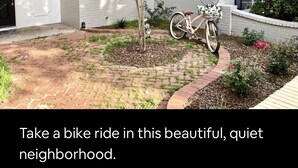 A residential house with a brick driveway, a bicycle parked outside, and a small tree in the front yard. - BestStays@Flowers Near UT Tyler large groups welcome (Tyler)