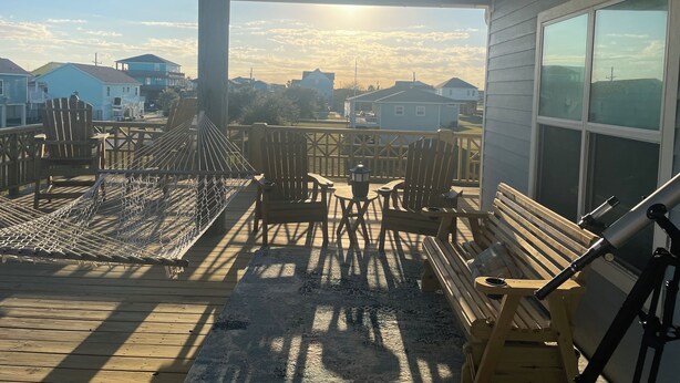A wooden deck with a hammock, chairs, and a telescope. - Relax and unwind in this Beautiful and Spacious smoke-free and pet-free home! (Port Bolivar)