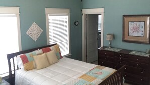 A bedroom with a bed, a dresser, a ceiling fan, and a framed picture on the wall. - Relax and unwind in this Beautiful and Spacious smoke-free and pet-free home! (Port Bolivar)