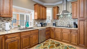 A kitchen with wooden cabinets, a tiled backsplash, and a stainless steel range hood.