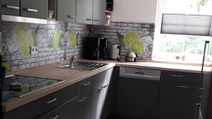 A modern kitchen with grey cabinets, a stainless steel sink, and a window providing natural light.