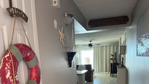 A hallway with a decorative life preserver, a ceiling fan, and a 'Welcome' sign.