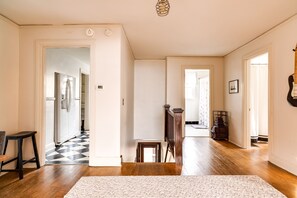 Stunning hallway with a checkered floor pattern leading to various rooms, featuring a staircase and decorative accents.