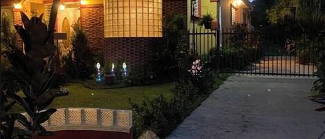 A modern two-story house with a brick facade, a balcony, and a well-lit entrance.