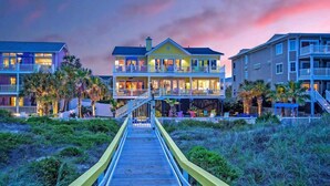 A beachfront hotel with a wooden boardwalk leading to the entrance, multiple balconies, and a view of the ocean. - Casa Banana Oceanfront on Ocean Blvd, 6 BD, sleeps 20, pool,hot tub, elevator (Isle Of Palms)