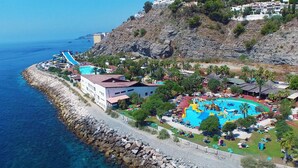 A coastal resort with a large swimming pool, a water park, and a rocky shoreline. - APARTMENT 2 MINUTES AWAY FROM PUERTA DEL MAR BEACH  (Almuñécar)