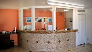 A reception area with a curved counter, a tiled wall, and a door.