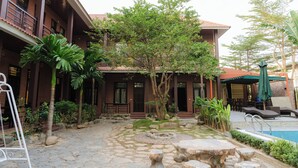 A courtyard with a stone pathway, a pool, and a building with a red-tiled roof. - Viet Xua Homestay (Ninh Binh)