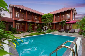 A hotel with a swimming pool, multiple balconies, and a well-maintained garden. - Viet Xua Homestay (Ninh Binh)