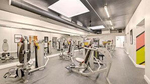 A gym with various exercise machines, mirrors, and a clean, modern design.