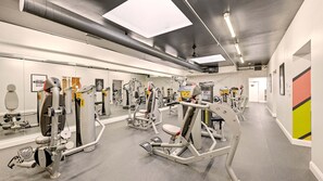 A gym with various exercise machines, mirrors, and a clean, modern design.