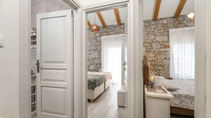 Una camera da letto con parete in pietra, un letto con copriletto decorato e un comodino con una lampada.