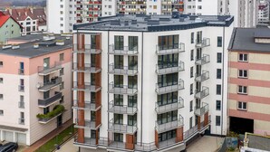 A multi-story residential building with balconies, a flat roof, and a paved ground floor. - Ferienwohnung am Meer, Urlaub auf der Insel Usedom, Appartement Centrum (Swinoujscie)