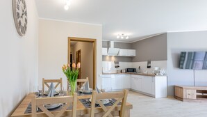 A modern kitchen with white cabinets, a microwave, and a flat-screen TV mounted on the wall. - Ferienwohnung am Meer, Urlaub auf der Insel Usedom, Appartement Centrum (Swinoujscie)