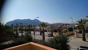 Zona residencial amb cases, palmeres i una muntanya al fons.