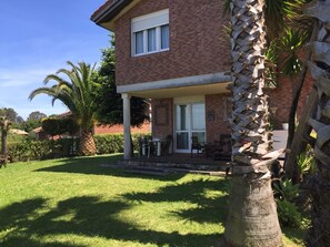 A two-story house with a covered patio, a brick exterior, and a well-maintained lawn. - House with a spectacular view of the bay (Seña)