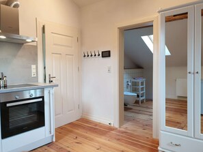 A modern kitchen with a built-in oven and a white cabinet.